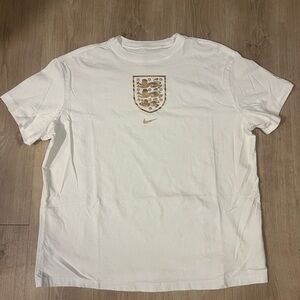 Nike Men's White Tee with Gold Emblem
